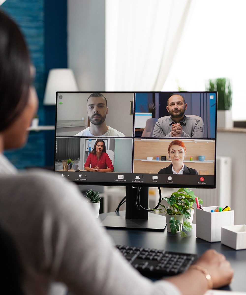 An image of an African American in a teleconference with multiple other people.